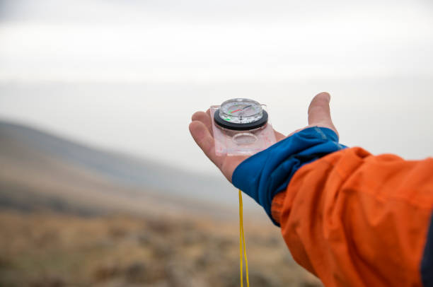 The hiker holds a compass in his hand. Travel photography